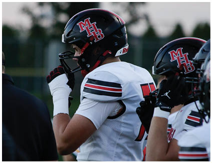 A football player with a white jersey and red stripes. Description generated by AI