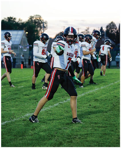 A group of football players on a field. Description generated by AI