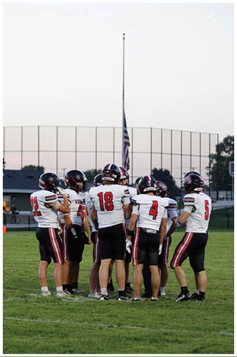 A group of football players on the field. Description generated by AI
