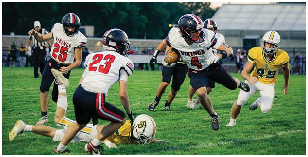 A football player in a yellow jersey is running towards the ball. Description generated by AI