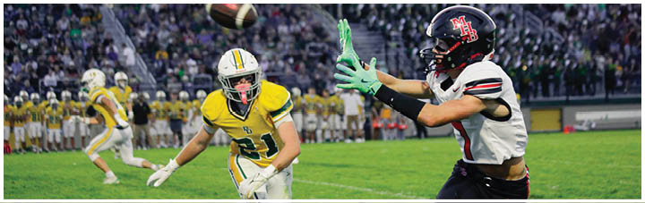 A football player in a white jersey catching a ball. Description generated by AI