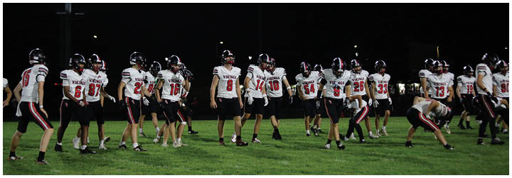 A group of football players in black and red uniforms. Description generated by AI