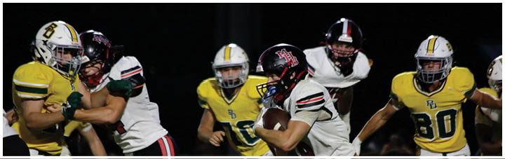 A football game is in progress with players wearing numbered jerseys. Description generated by AI