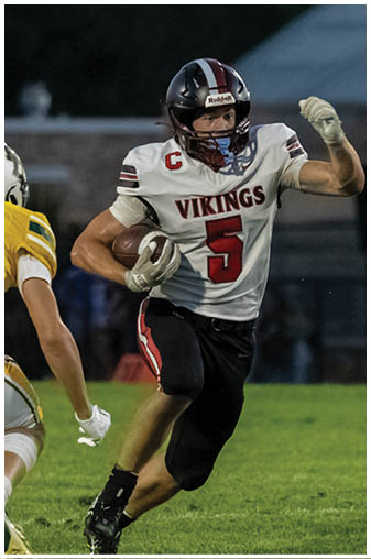 A football player wearing a black and white jersey with the number 5 on it. Description generated by AI