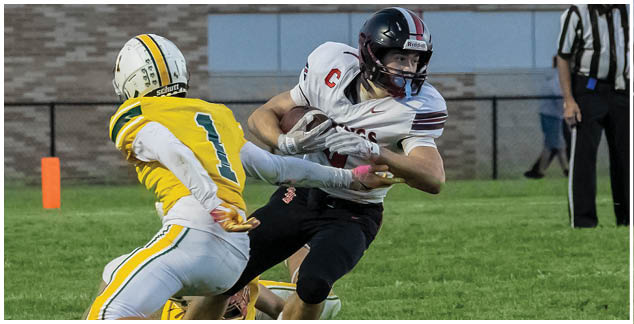 A football player in a yellow jersey is tackled by another player. Description generated by AI