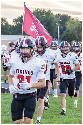 A group of football players wearing black and red jerseys. Description generated by AI