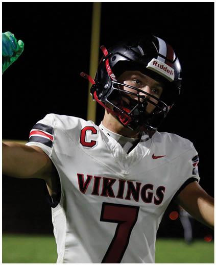 A football player wearing a white jersey with the number 7 on it. Description generated by AI