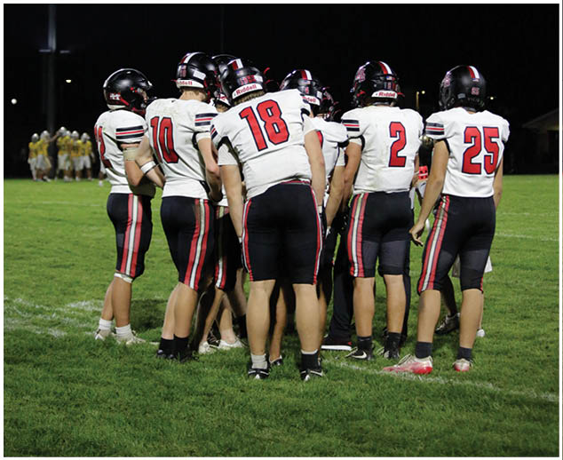 A group of football players on a field. Description generated by AI