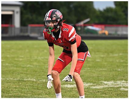 A football player in a red and black uniform. Description generated by AI
