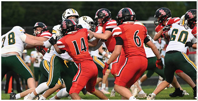 A group of football players in red and green uniforms playing a game. Description generated by AI