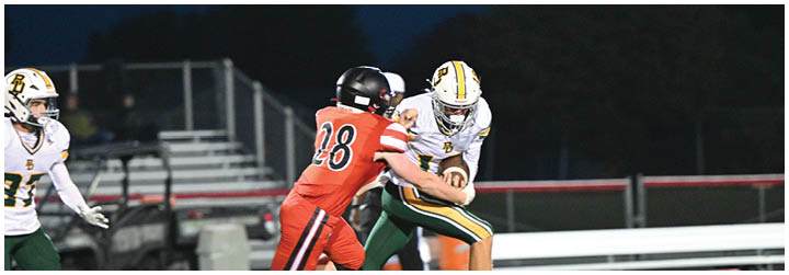 A football player in a red jersey is tackled by another player. Description generated by AI