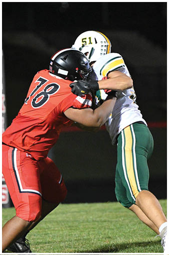 A football player in a red jersey is tackling another player. Description generated by AI
