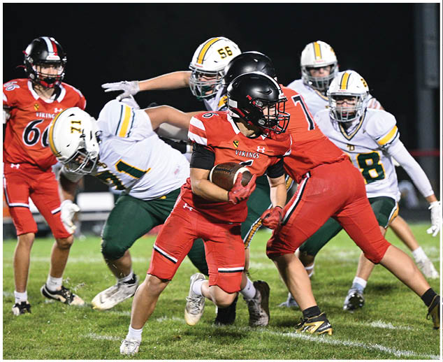 A football player in a red jersey is running with the ball. Description generated by AI