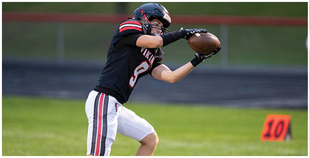 A football player in a white jersey with the number 4 on it. Description generated by AI