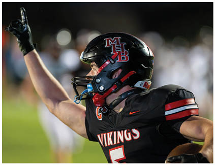 Two football players wearing black and white uniforms. Description generated by AI