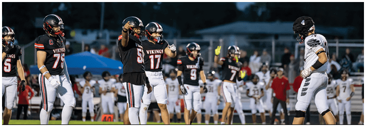A group of football players in black and red uniforms. Description generated by AI