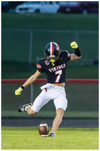 A man wearing a white jersey with the number 7 on it is jumping in the air to catch a football. Description generated by AI