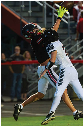 A football player wearing a black and white jersey with the number 5 on it. Description generated by AI