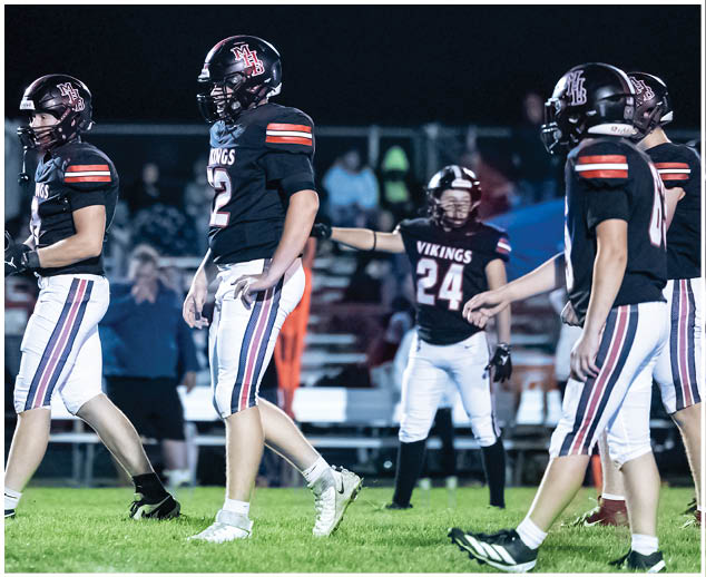A group of football players on a field. Description generated by AI