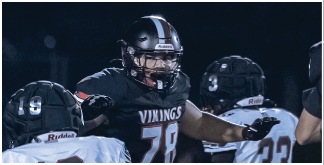 A group of football players on a field. Description generated by AI