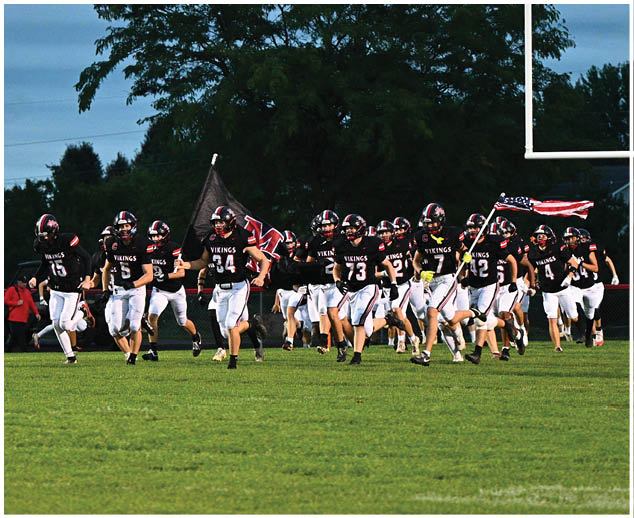 A group of football players on a field. Description generated by AI