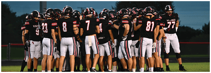 A group of football players in black and red uniforms. Description generated by AI