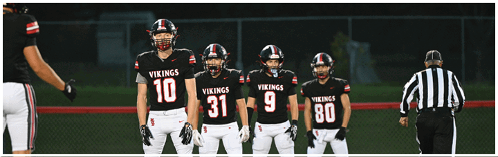 A football game is in progress with players wearing numbered jerseys. Description generated by AI