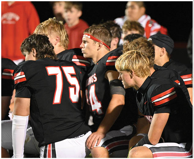 A group of football players on a field. Description generated by AI