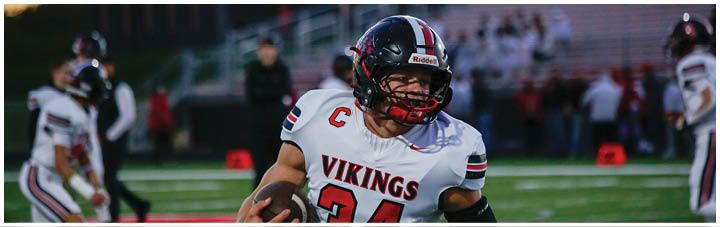 A football player wearing a black and white jersey with the number 18. Description generated by AI