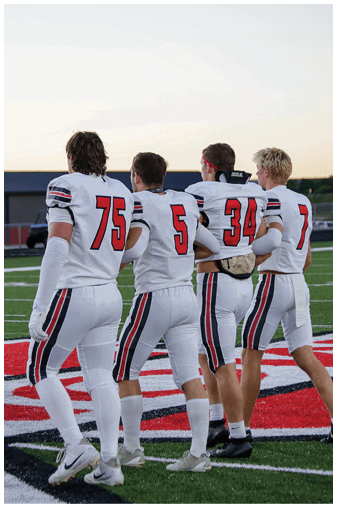 A group of football players on a field. Description generated by AI