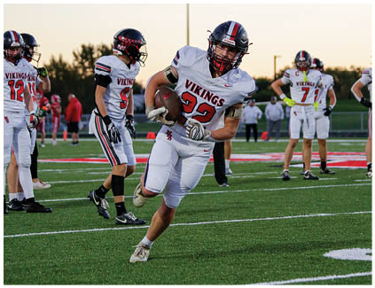 Two football players wearing black and white uniforms. Description generated by AI