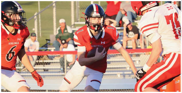 A football player in a black jersey is running with the ball. Description generated by AI