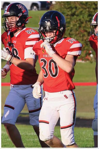 A football player wearing a black and white jersey with the number 5 on it. Description generated by AI