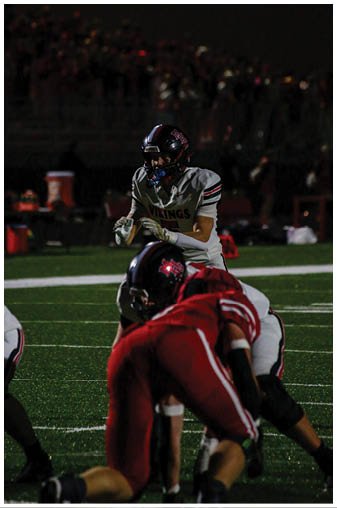 A football player in a black jersey with the number 6 on it. Description generated by AI