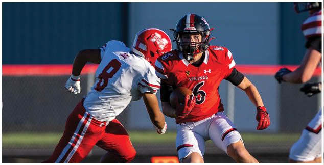 A football player in a black jersey is running with the ball. Description generated by AI