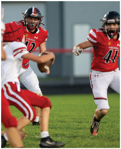 A group of football players on a field. Description generated by AI