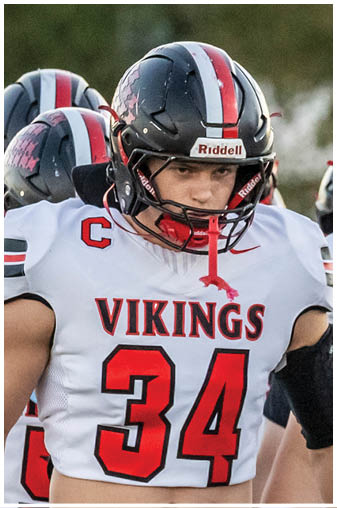 A football player in a black jersey with the number 6 on it. Description generated by AI