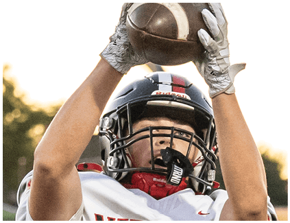 A football player wearing a black and white jersey with the number 12 on it. Description generated by AI