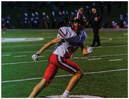 Two football players wearing black and white uniforms. Description generated by AI