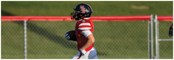 A group of football players on a field. Description generated by AI