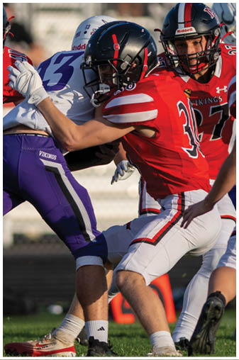 A football player wearing a black and white jersey with the number 5 on it. Description generated by AI