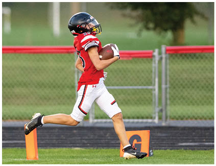 A football player in a yellow jersey is running with the ball. Description generated by AI