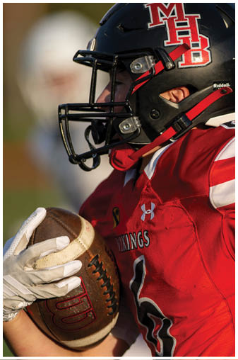 A football player wearing a black and white jersey with the number 5 on it. Description generated by AI