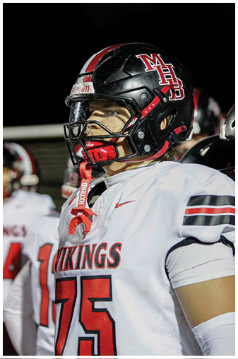 A football player in a black jersey with the number 6 on it. Description generated by AI