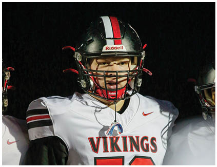 A football player wearing a black and white jersey with the number 12 on it. Description generated by AI