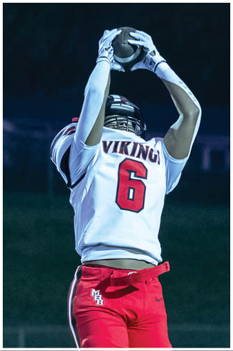 A football player in a black jersey with the number 6 on it. Description generated by AI