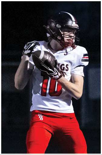 A football player in a black jersey with the number 6 on it. Description generated by AI