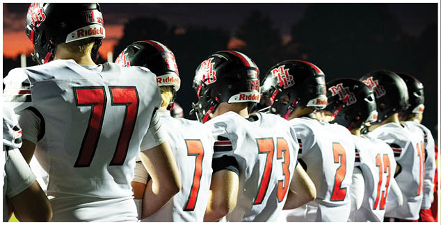 A football player in a white jersey with the number 4 on it. Description generated by AI
