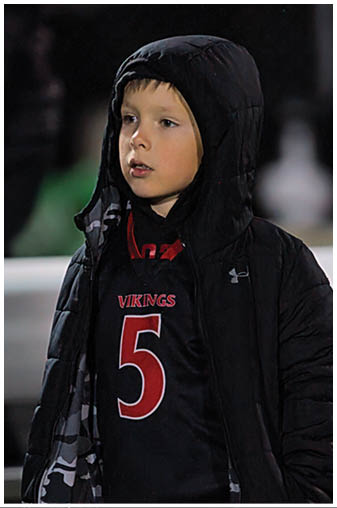 A football player in a black jersey with the number 6 on it. Description generated by AI