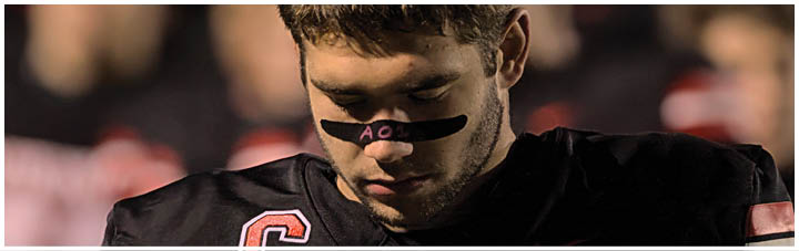 A football player wearing a black and white jersey with the number 18. Description generated by AI